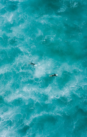 Серферы в бирюзовой воде, фото с высоты 