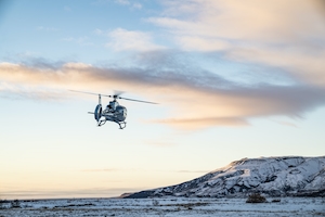 Вертолет, поднимающийся с земли и летящий в небо