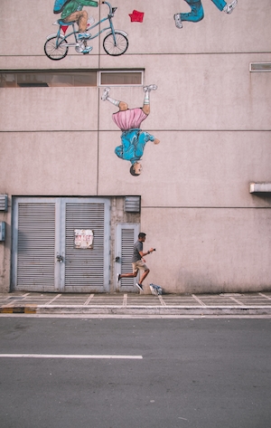 человек бежит на фоне здания с граффити 