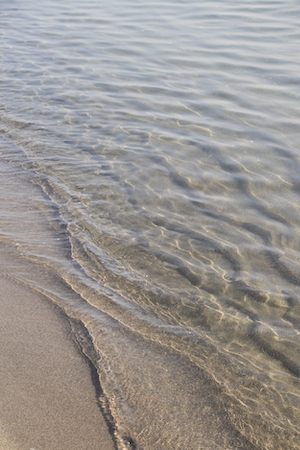 рябь на прозрачной воде во время прилива на песчаном пляже 