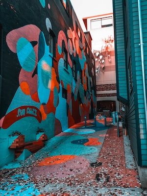 маленькая улочка с яркими граффити на стенах 