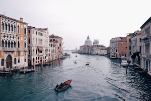 Канал в Венеции днем, здания на воде, гондола с гондольером 
