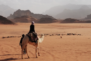 песчаная дюна, пески в пустыне, пейзаж в пустыне, горы на горизонте, человек на верблюде 