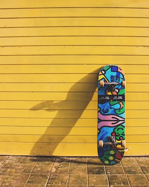 разноцветный скейтборд на фоне желтой стены 