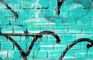 крупный план кирпичной стены с бирюзовым граффити 