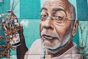 портрет человека в очках с баллончиком краски, граффити на стене 