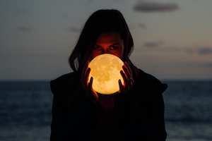 девушка держит в руках фонарь в форме луны 