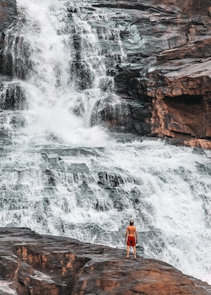 большой природный водопад, человек на фоне водопада 
