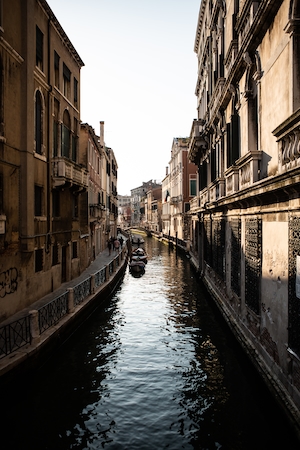 Канал в Венеции на днем здания на воде, гондола с гондольером 
