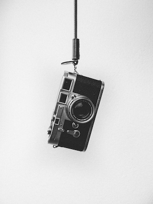 черно-белая фотография фотоаппарата на веревочке 