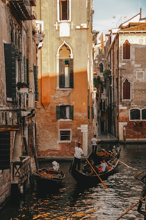 Канал в Венеции на закате, здания на воде, гондола с гондольером 