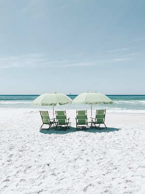 зеленые лежаки на белом песке, прибрежная полоса, голубое море 