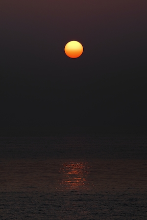 Восход солнца над морем, большое красное солнце 