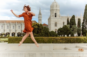 Девушка в прыжке на фоне архитектуры в Лиссабоне 