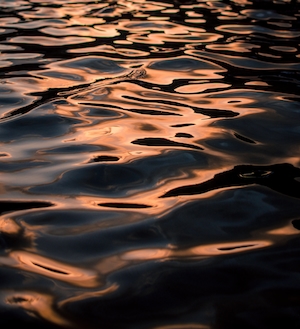 морская поверхность с бликами света, рябь на воде, во время заката 