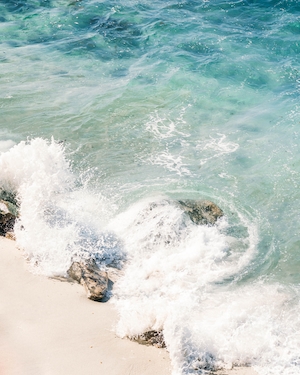 вода, крупный план, волна и морская пена на песчаном пляже 