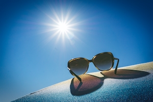 солнечные очки на фоне солнца на голубом небе 