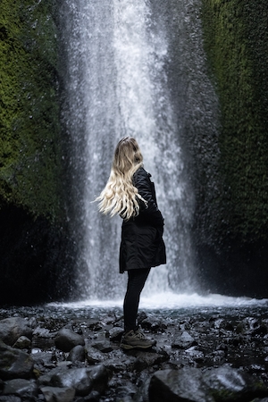 Торморк, Исландия,большой водопад, высокая отвесная скала, человек на фоне водопада 