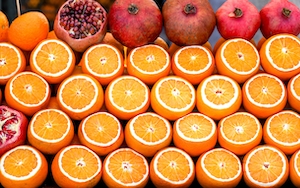 Апельсины и гранаты на прилавке рынка