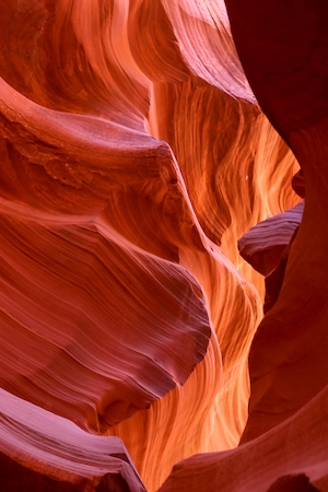 Слот-Каньон с извилистыми стенами, свет в красных скалах каньона, небо сквозь красные стены каньона 