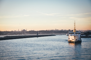 Стамбул, белый корабль в проливе, городской горизонт 