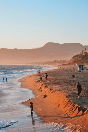 закат на море, пляж во время заката, люди гуляют по пляжу 