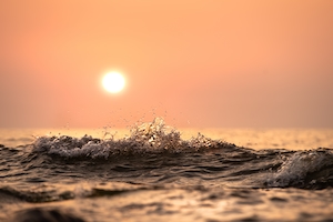 Небольшие волны обрушиваются на немецкое побережье Балтийского моря во время заката 