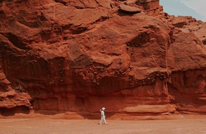 Марс, космонавт, фотосессия в костюме космонавта на фоне красных скал 