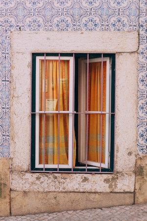 Уличная фотография окна с желтыми занавесками 