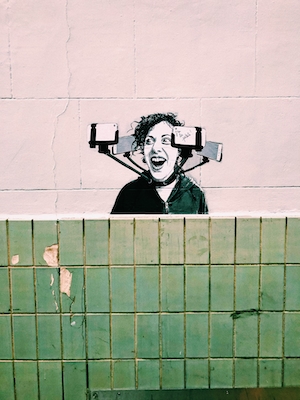 граффити на стене, портрет зависимого от гаджетов человека 