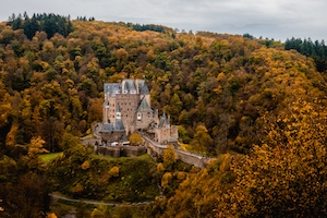 Бург Эльц в Германии осенью, замок в окружении осеннего леса