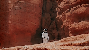 человек в костюме космонавта на фоне красных скал 