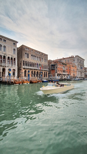 Канал в венеции днем, здания на воде, желтая лодка