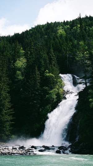 Водопад с горного леса в реку, водопад в лесу, поток водопада в лесу, большие скалы