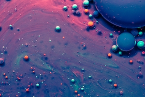 Пузырьки чернил и масла, плавающие в волне цветов. 