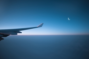 Фото крыла самолета из окна иллюминатора, облака и луна 