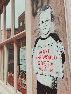 граффити на стене, мальчик держит плакат 