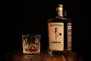 Снимок продукта из бутылки бурбона Orphan Barrel Barterhouse и хрустального бокала Waterford.