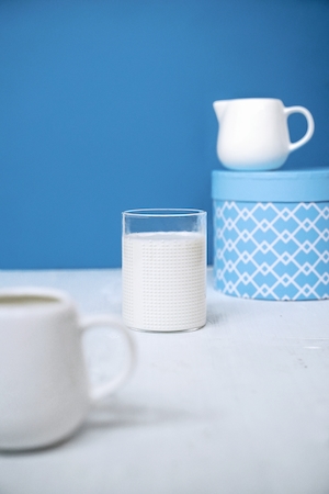 молоко, стакан молока, на голубом и белом фоне