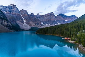 Фотография канадских Скалистых гор, сделанная с озера Морейн в национальном парке Банф. Горное озеро, отражение неба и гор в воде, лесу у озера и гор 