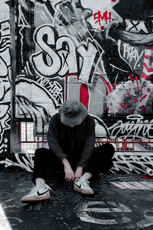 человек сидит на фоне граффити на бетонной стене 