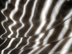 Линии света тени на текстильной подушке. 