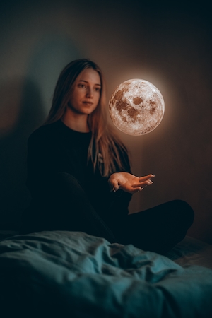 девушка держит луну в руках 