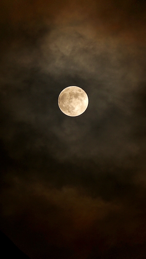 Лунное затмение, полная луна на темном небе, облака 
