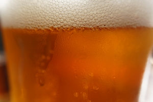 Крупный план стакана с пивом, запотевший стакан, пивная пена 