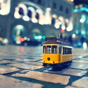 Миниатюра желтого трамвая на улице в Лиссабоне 