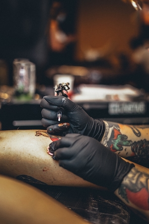 татуировщик делает тату 