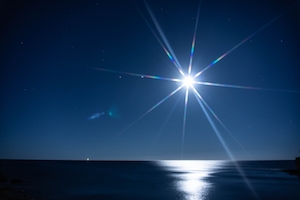 Полная луна на берегу моря с длительной экспозицией