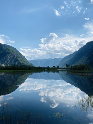 Горное озеро, отражение неба и гор в воде, лесу у озера и гор 