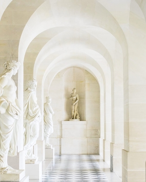 Белые мраморные скульптуры в арочном коридоре 